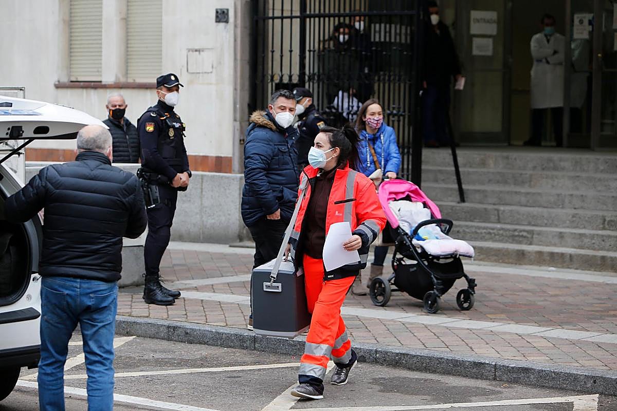 Una sanitaria transporta una nevera con vacunas junto al centro de salud San Juan