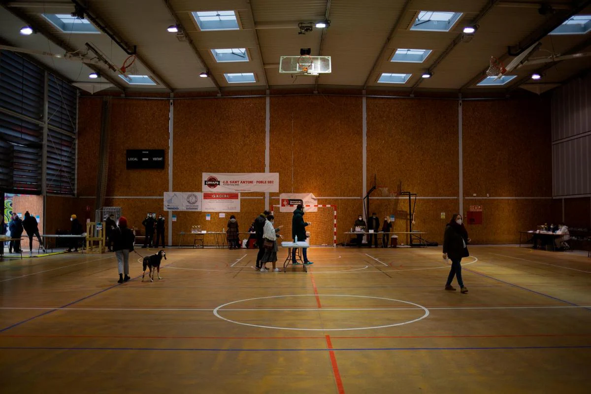 Varias personas se dirigen a votar en el Polideportivo Tres Xemeneies.