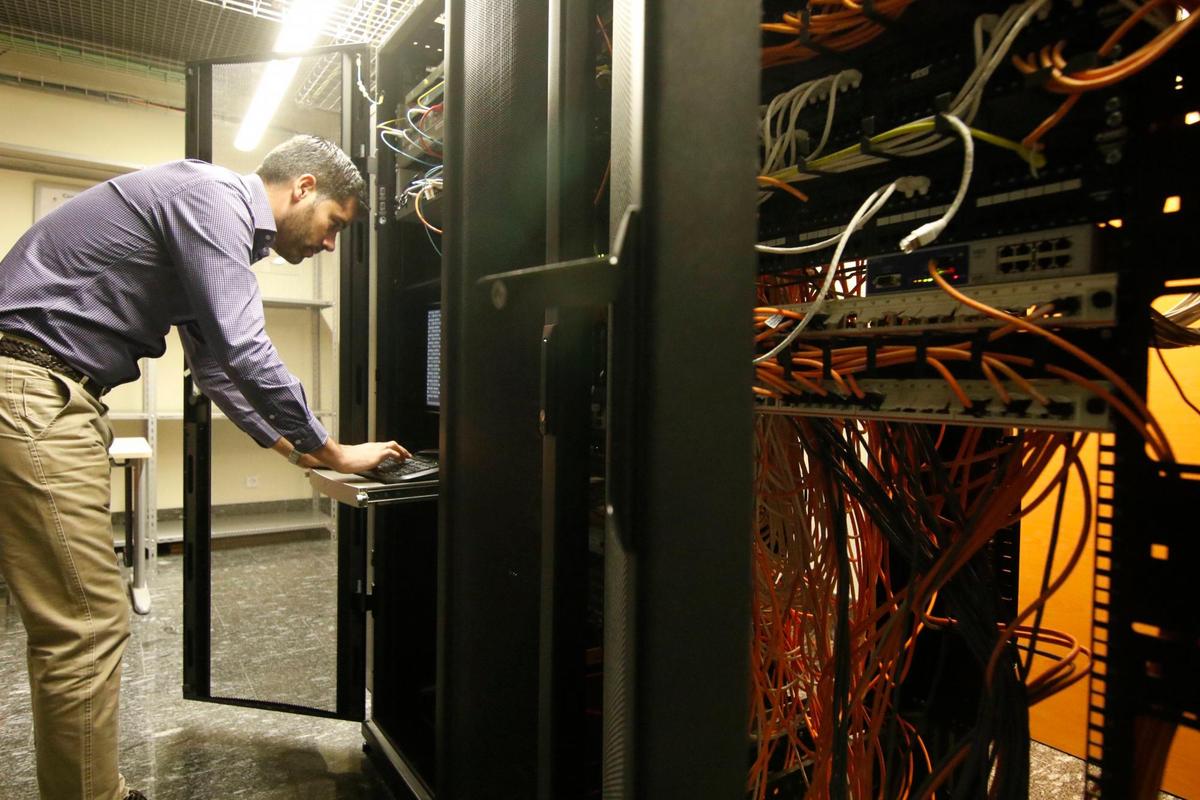 Un hombre trabajando en un centro de datos.