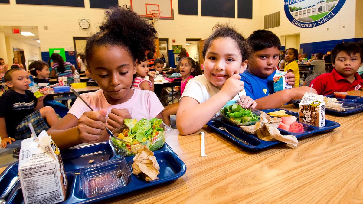 Varios niños en un comedor escolar.