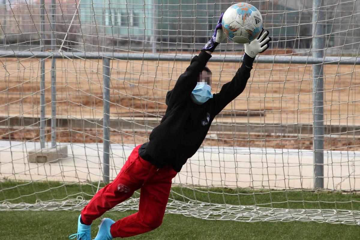 Estirada de un portero del Pizarrales para atrapar un balón en su primer entrenamiento con mascarilla.