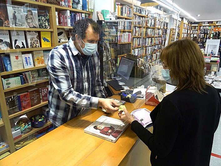 Julio Gómez entrega a una clienta un bono canjeable.