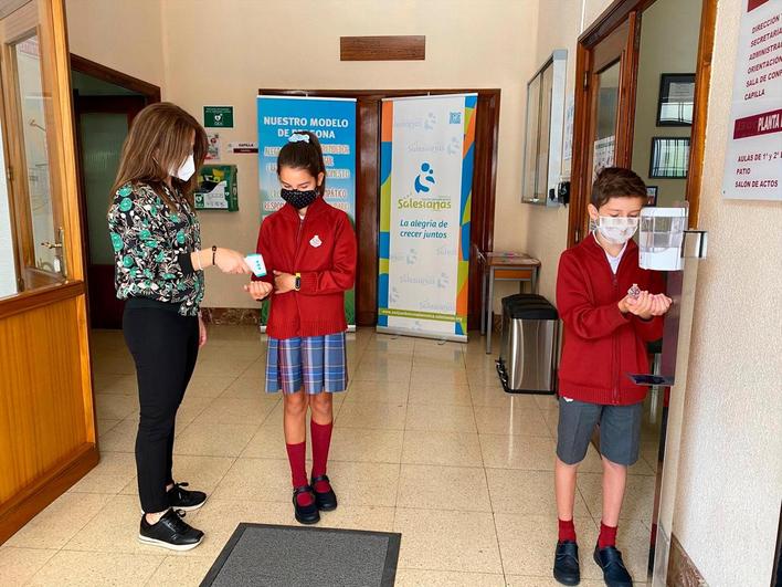 Una profesora toma la temperatura a una alumna en el colegio San Juan Bosco “Salesianas”