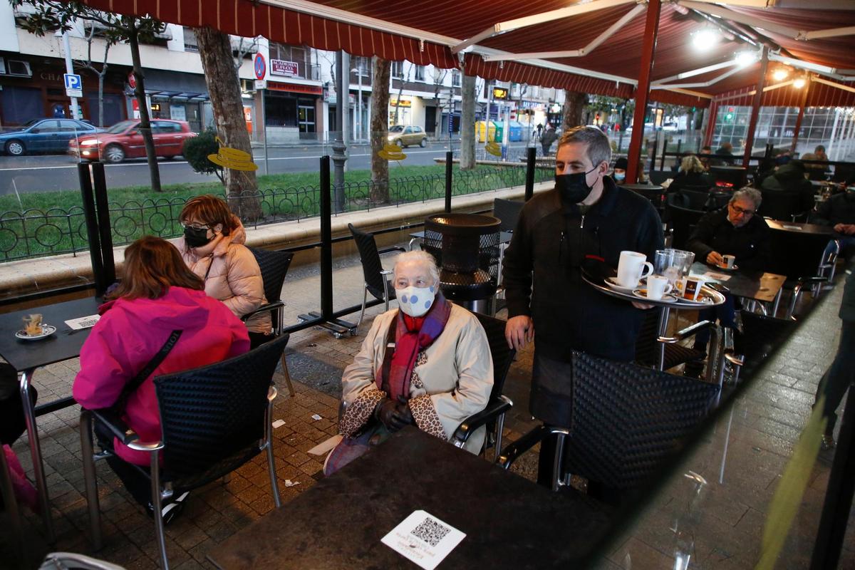 Un camarero atiende a los clientes de su terraza, en Salamanca.