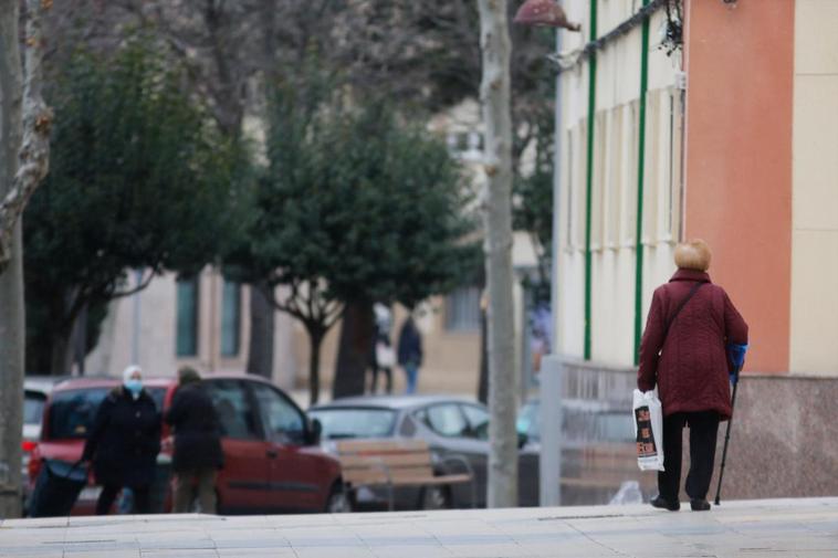 Una mujer mayor paseando por la calle.