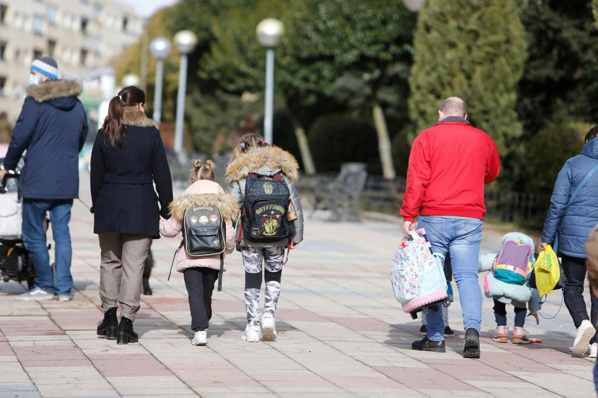 Niños y padres regresando a casa tras la salida del colegio.
