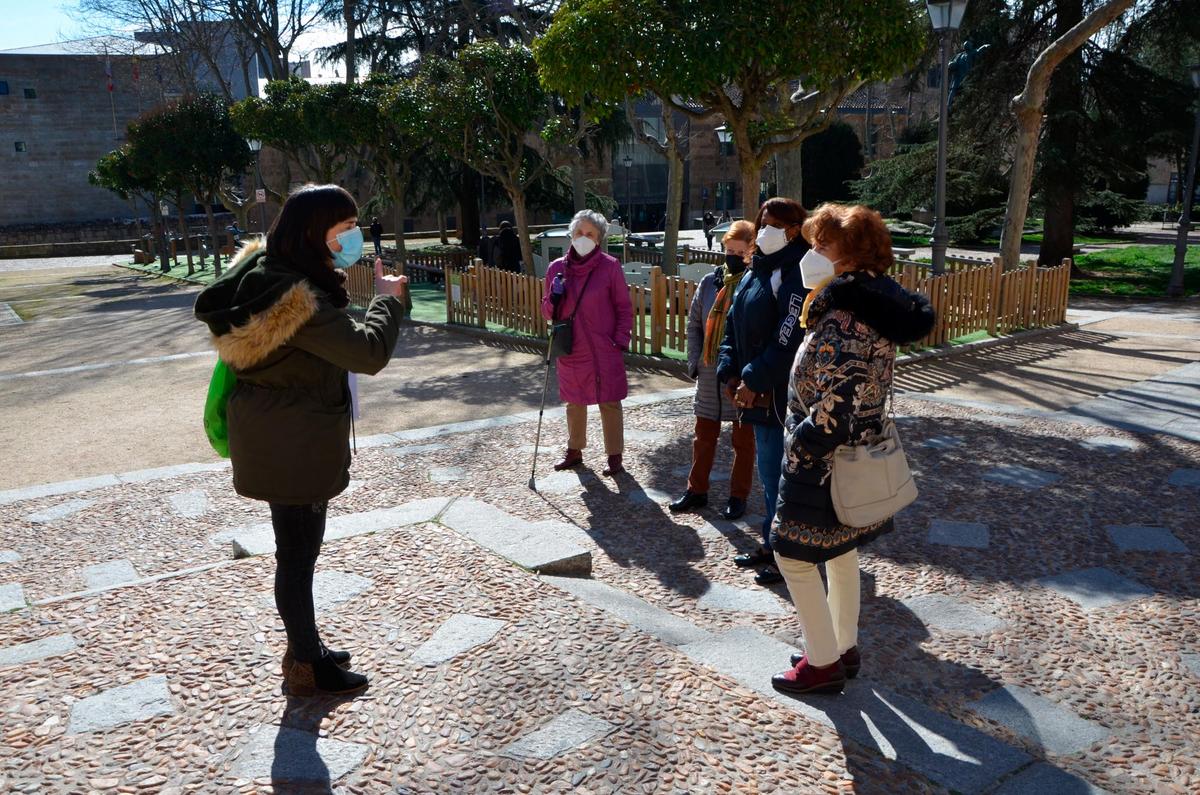 Una guía explica detalles del parque de Colón a varios mayores en una actividad