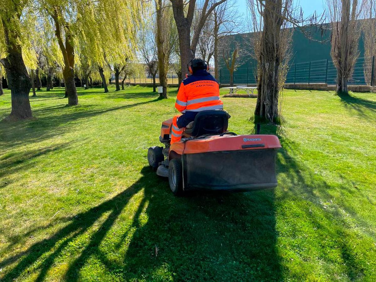 Un operario trabajando en la pradera de la piscina de Alba que tiene más de 8.000 metros cuadrados de césped.