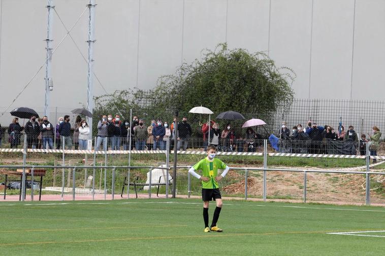 Padres viendo un partido de base del Unionistas desde detrás de las vallas del Reina Sofía