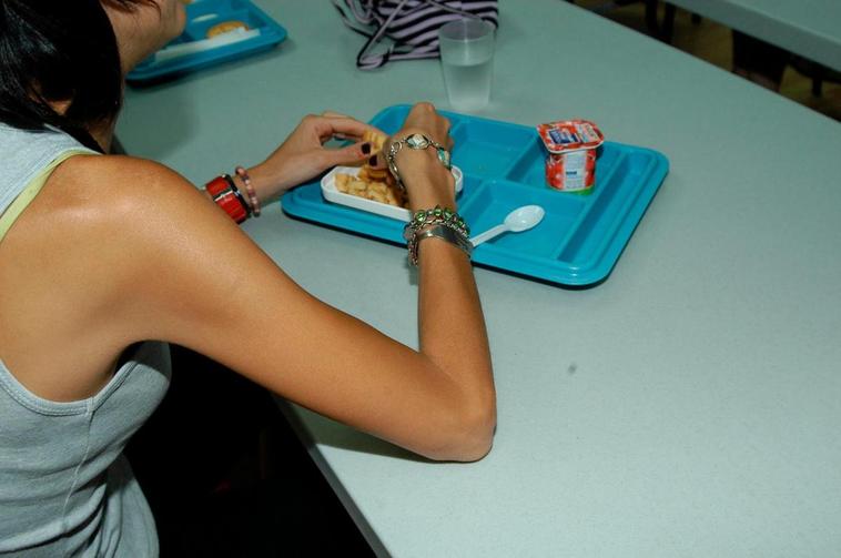 Una joven en tratamiento, con la bandeja de la comida.