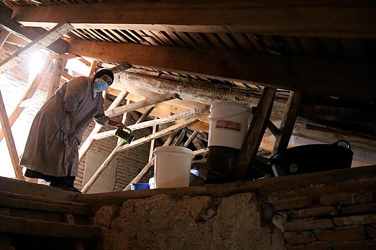 Una de las religiosas sube a la cubierta de la iglesia convento para supervisar el agua recogida en los cubos procedente de las filtraciones.