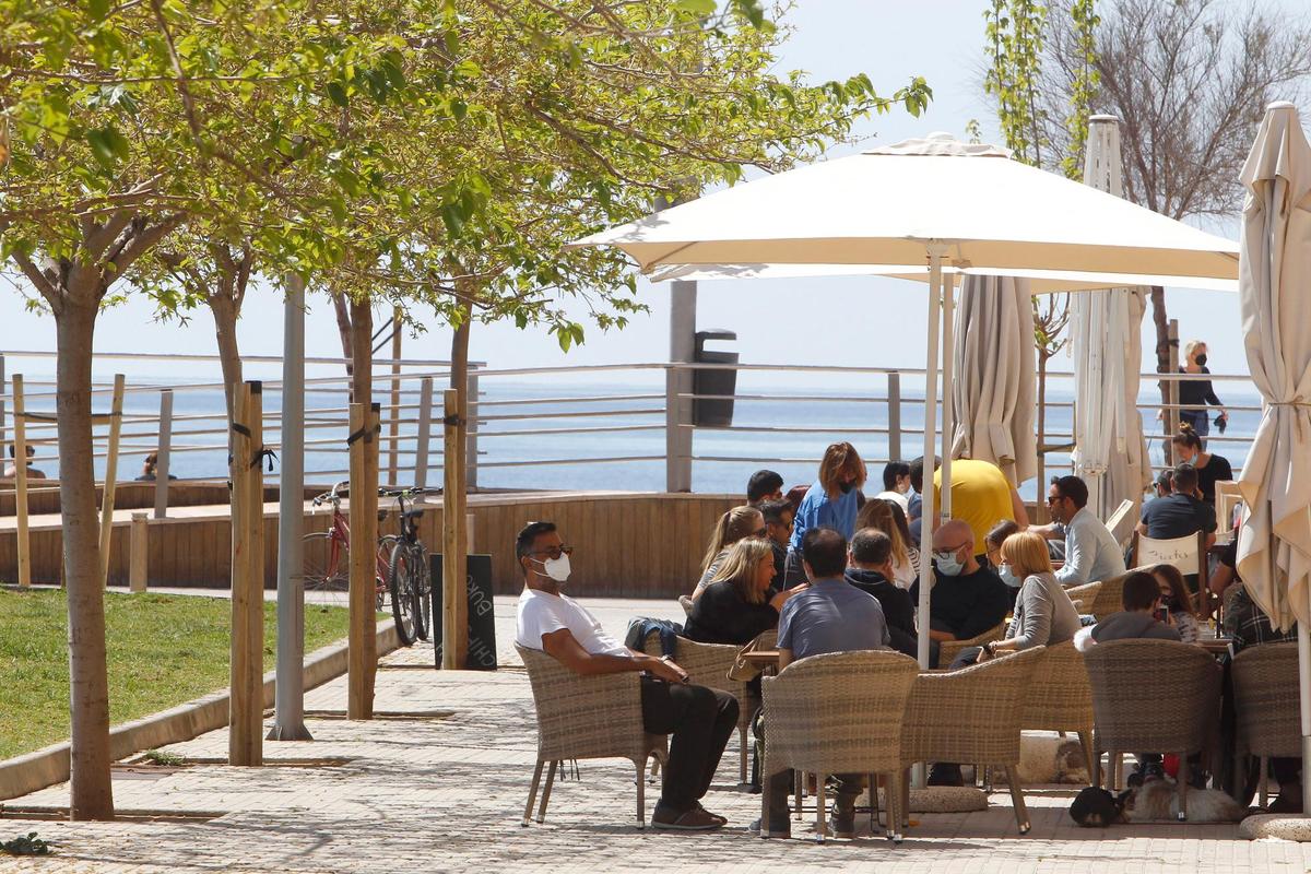 Varias personas en la terraza de un bar.