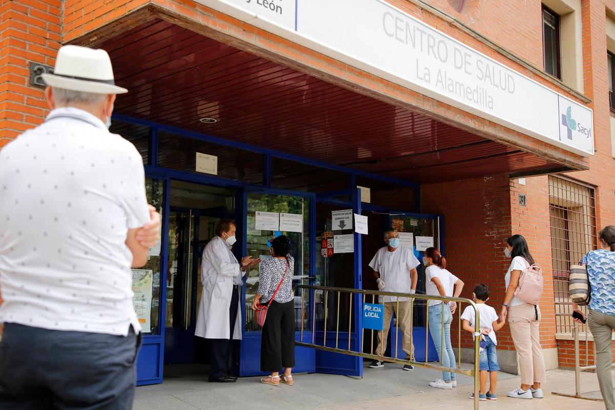 Pacientes esperan para entrar en las puertas del centro de salud de La Alamedilla.