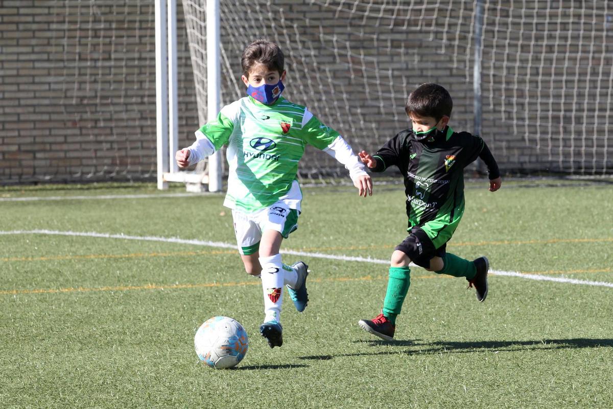 Un prebenjamín del Sporting Carbajosa trata de marcharse de otro pequeño del Jai Alai