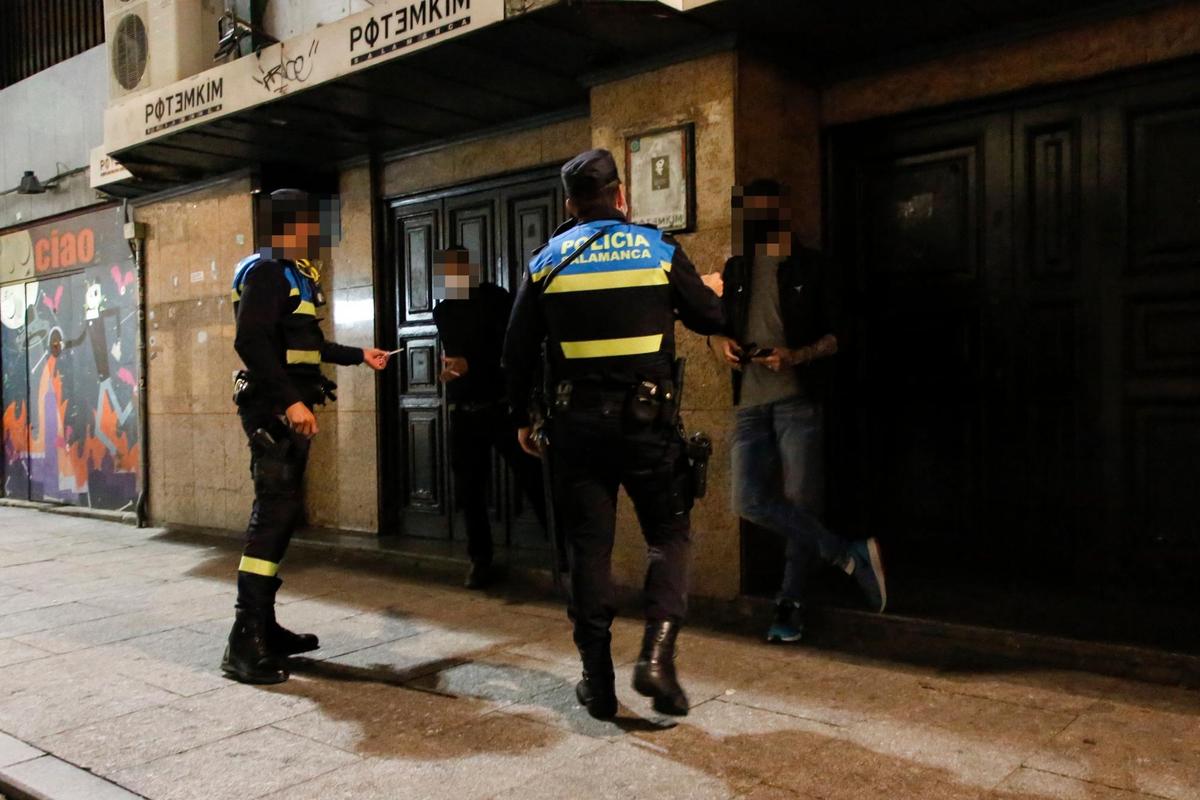 Dos agentes de la Policía Local identifican a dos jóvenes durante una noche.