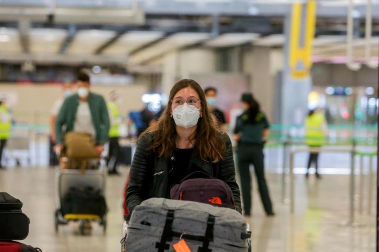 Una joven protegida con mascarilla camina por el Aeropuerto de Madrid-Barajas Adolfo Suárez.