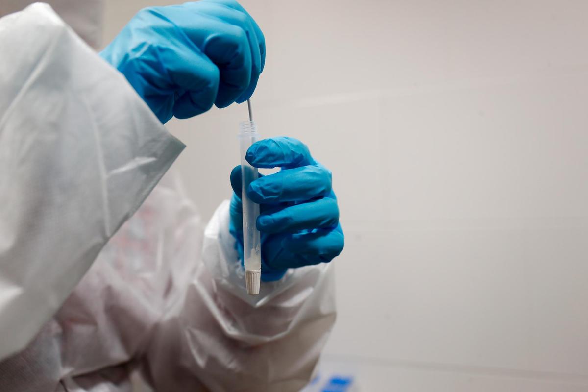 Un sanitario sostiene un test de antígenos