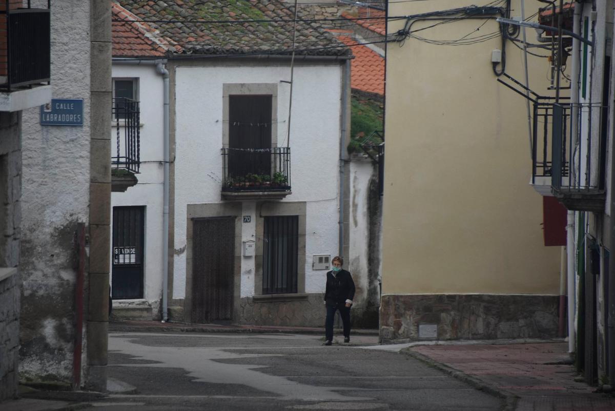 Una vecina camina por las solitarias calles de Villarino