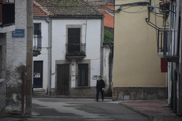 Una vecina camina por las solitarias calles de Villarino