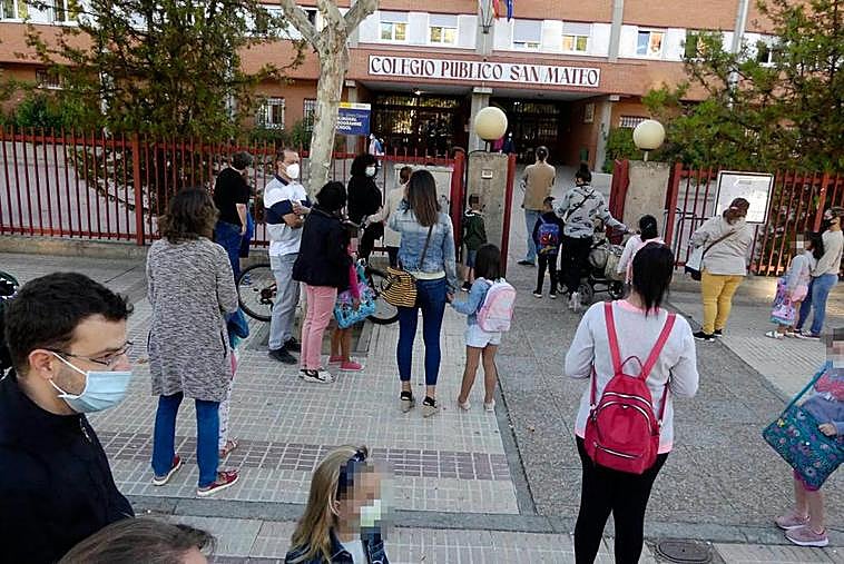 Alumnos y padres a las puertas de un centro escolar.