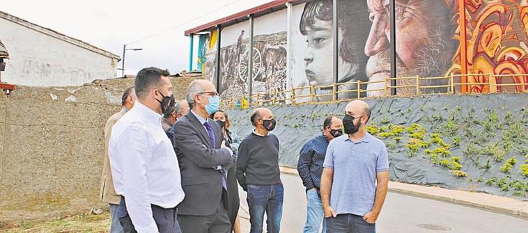 Santiago Castañeda y Javier Iglesias charlan con el artista Daniel Martín en la presentación de la ruta senderista y muralista.