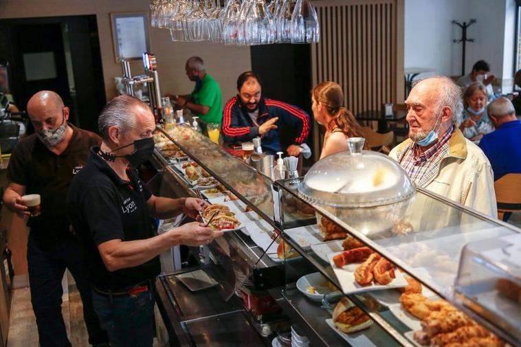 Varios clientes consumiendo en la barra en un establecimiento hostelero de Salamanca.