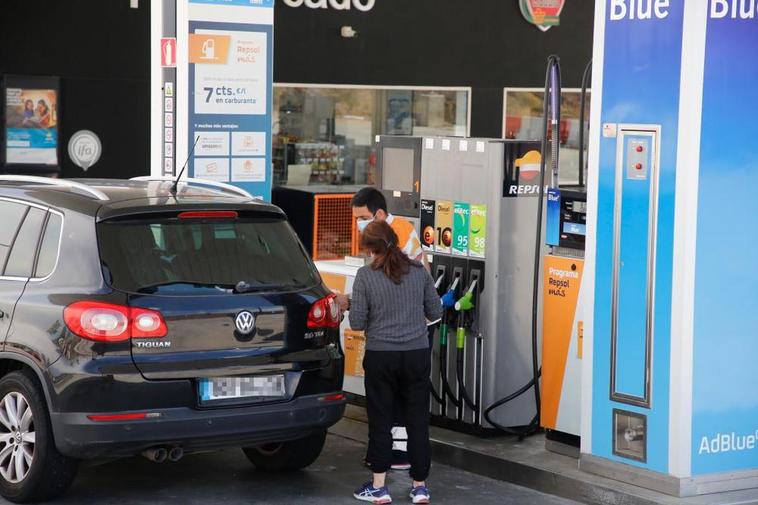 El empleado de una gasolinera sirviendo a un cliente.