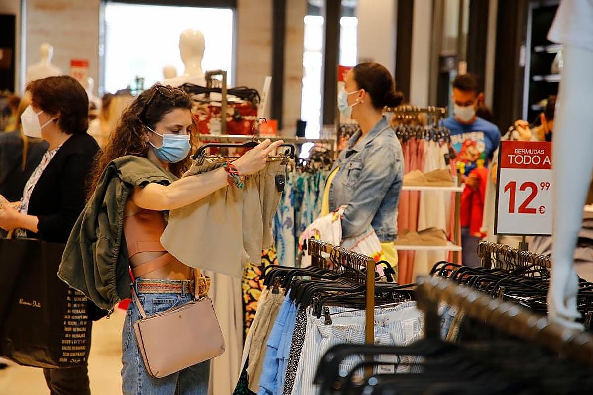 Una joven observa una prenda al inicio de rebajas.