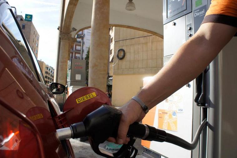 Empleado de una gasolinera echando carburante a un vehículo.