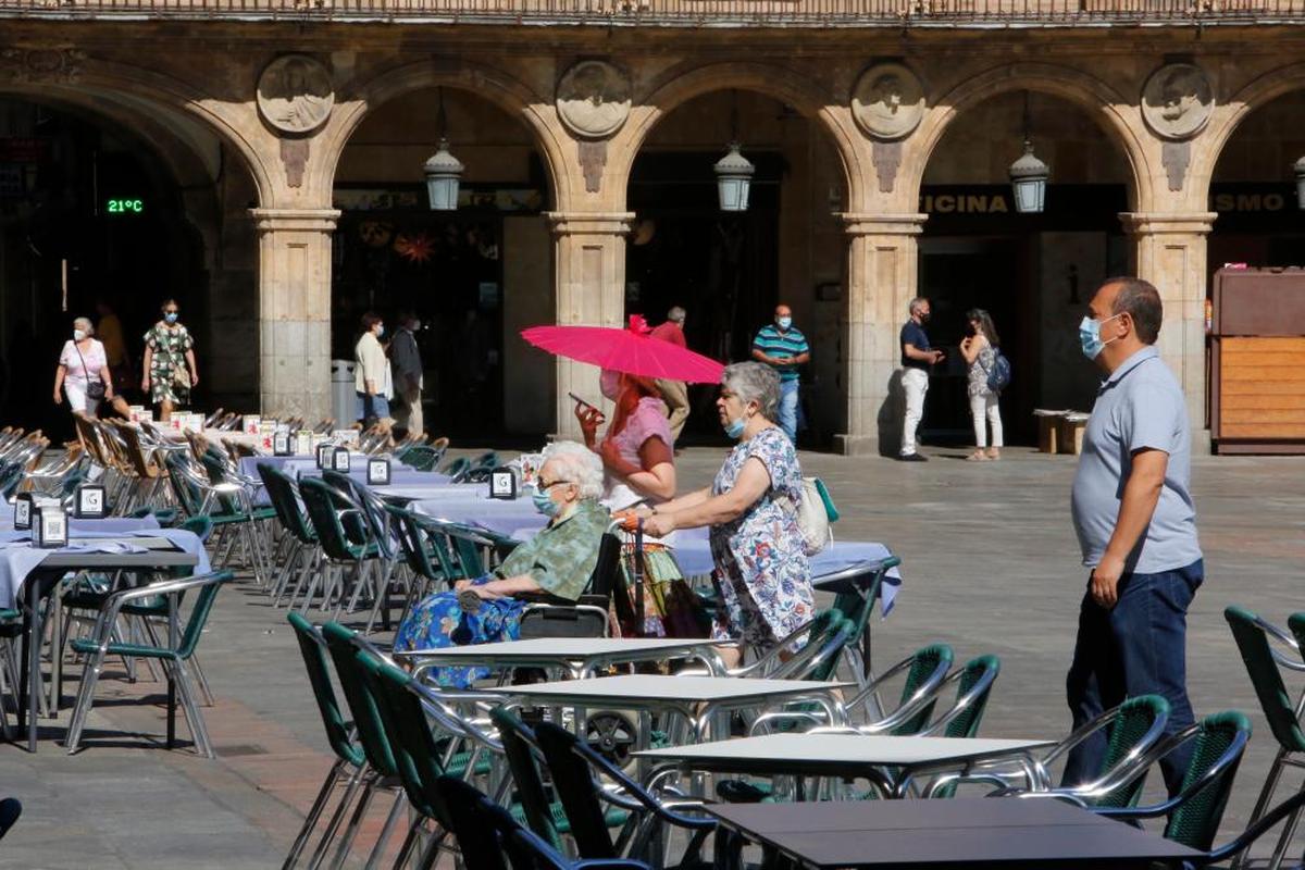 Una mujer se protege con una sombrilla del sol