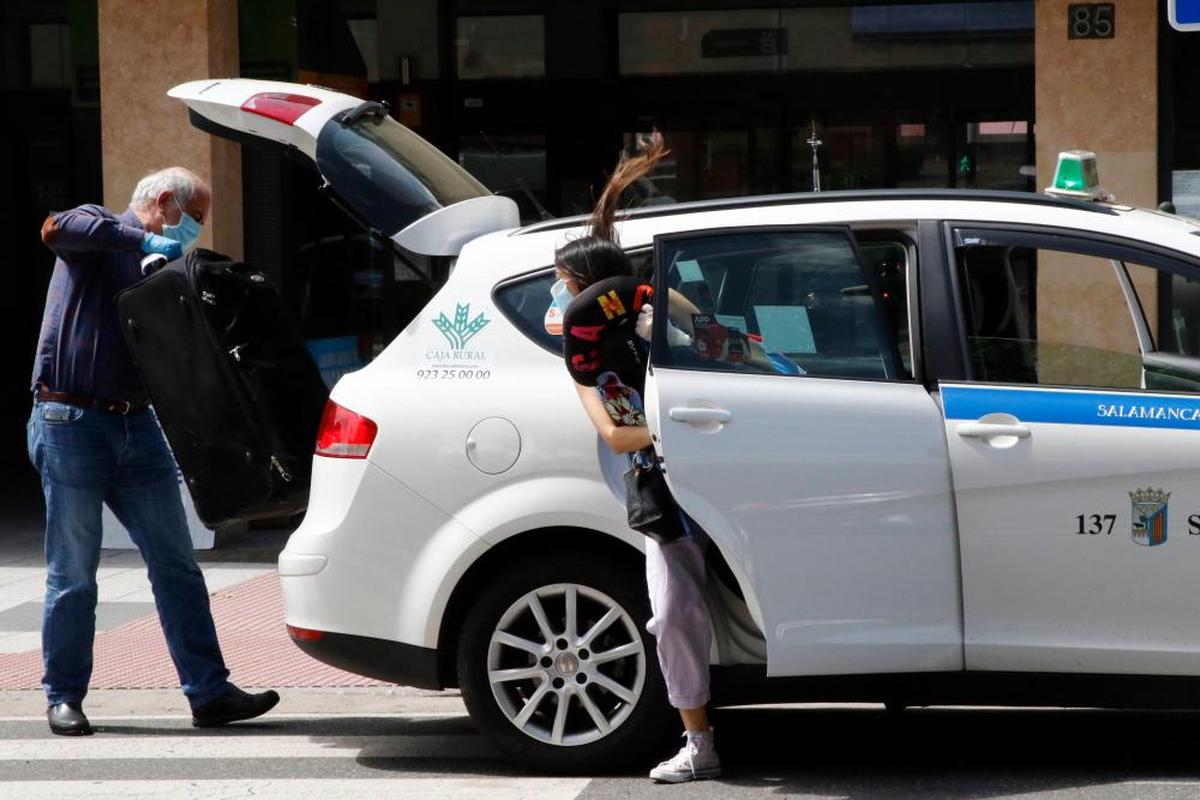 Un taxista recoge la maleta de una cliente junto a la estación de autobuses