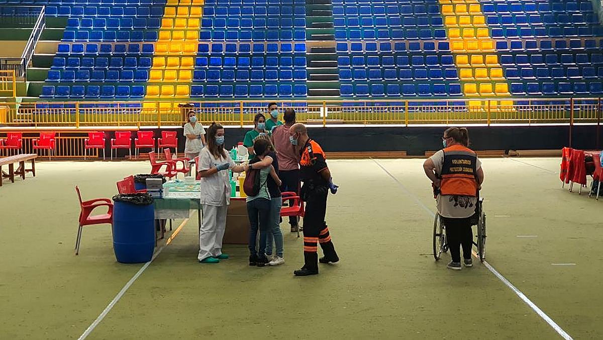 Momento en el que María Martín es abrazada por su hermana mientras el personal sanitario pone la vacuna