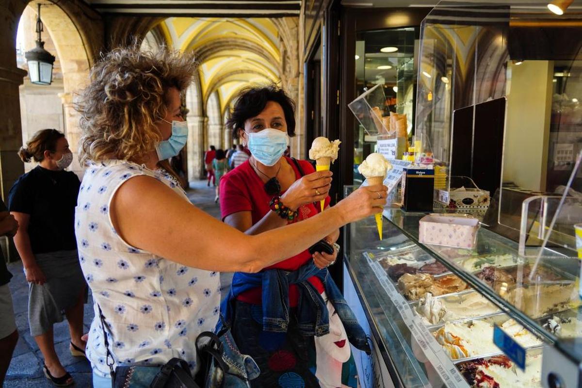 Dos mujeres compran un helado para refrescarse.