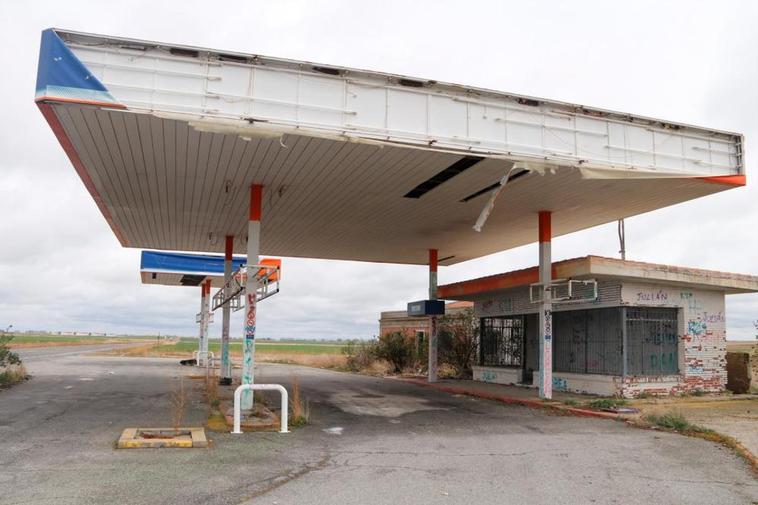 Maleza y pintadas invaden la antigua gasolinera de Rágama junto a la carretera CL-610.