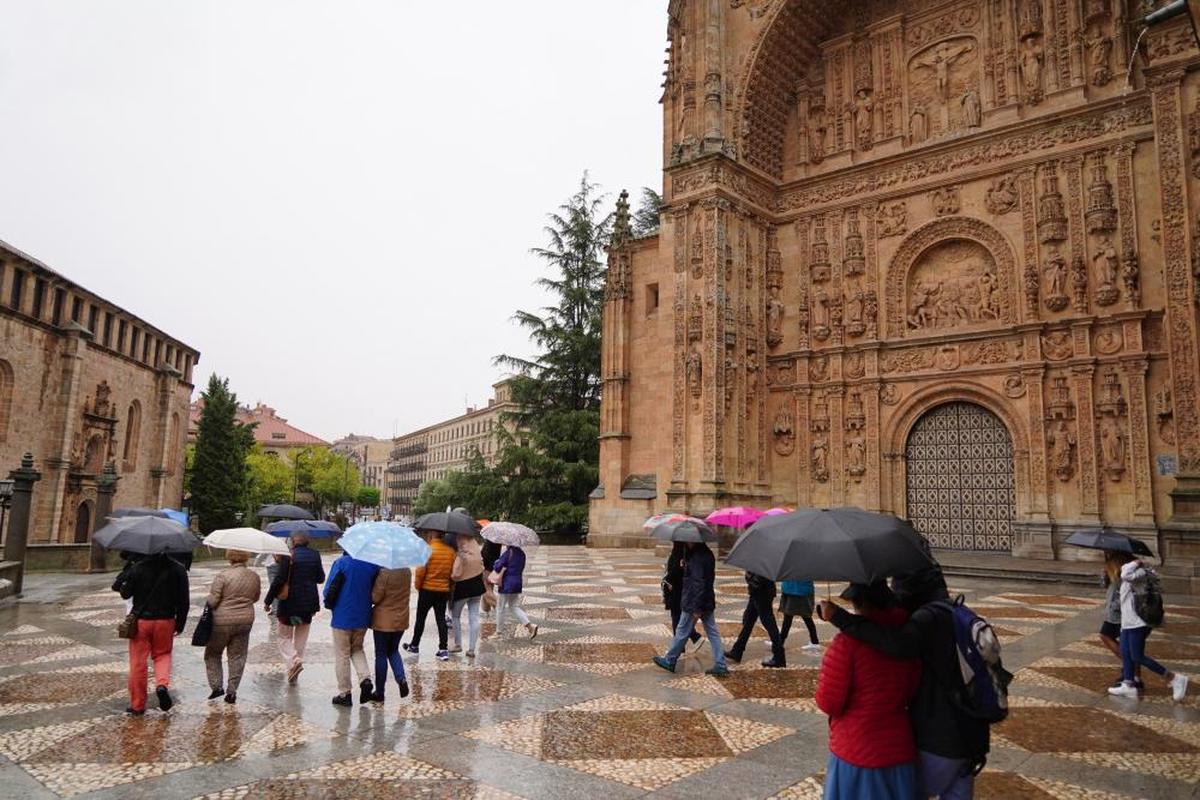 Turistas con paraguas en la plaza del Concilio de Trento, donde se desprendió un pináculo de Los Dominicos.