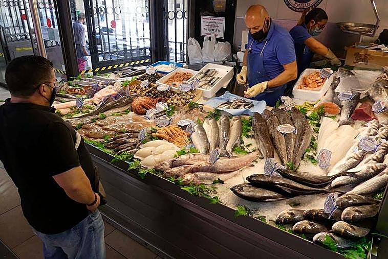 El cliente de una pescadería espera que le preparen su pedido, ayer en el Mercado Central.