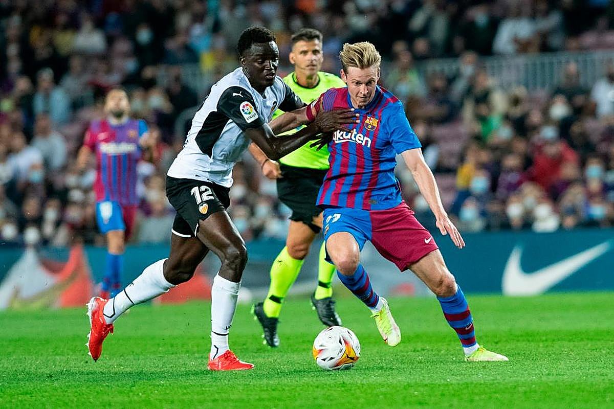 Frankie de Jong defiende el balón frente a un jugador del Valencia