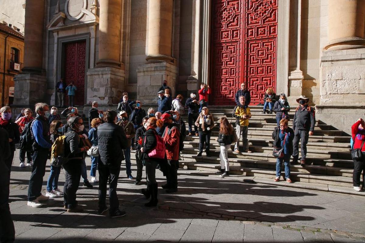 Un grupo de turistas extranjeros, en las escaleras de la iglesia de la Clerecía