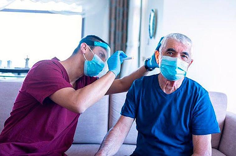 Un trabajador sanitario examina el oído de un paciente