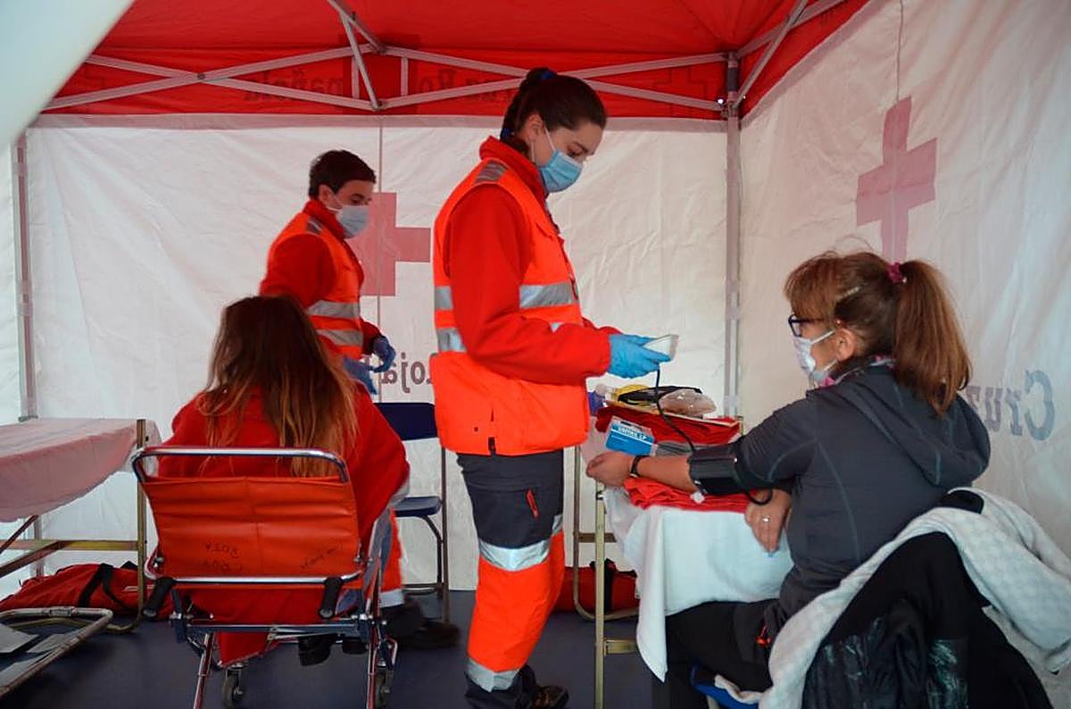 El personal de Cruz Roja mide tensión y pulso a los pacientes en una de las carpas instaladas en el pabellón.