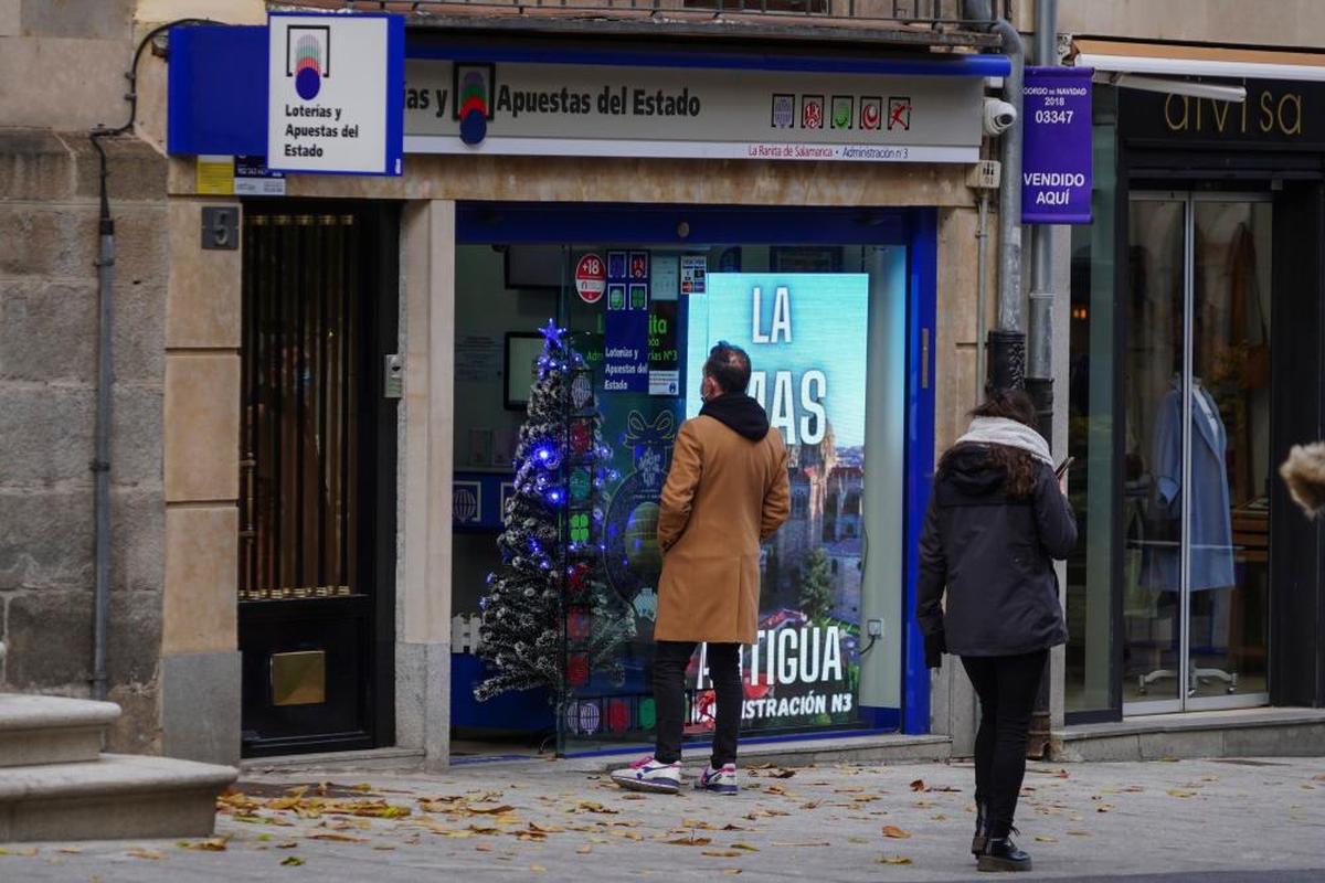 Un hombre, entrando en una administración de lotería de Salamanca.