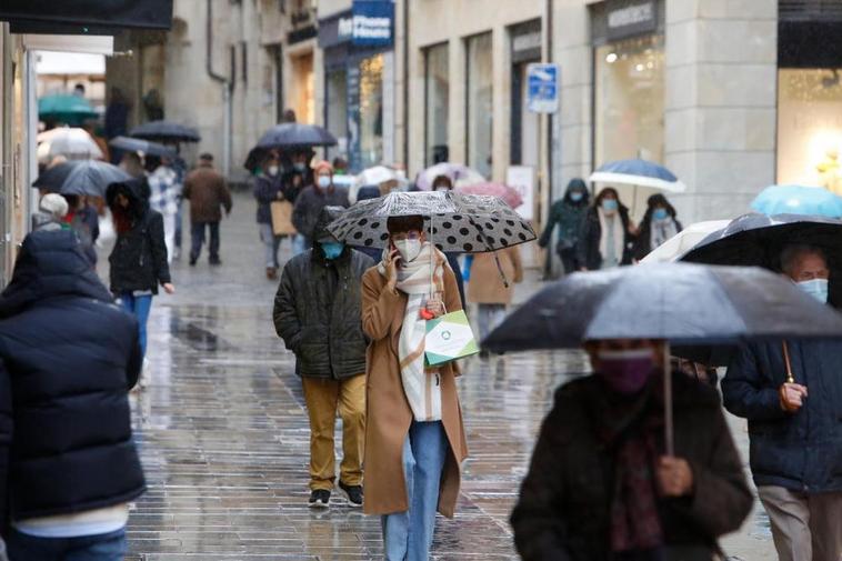 Gente con paraguas en una calle céntrica de Salamanca.