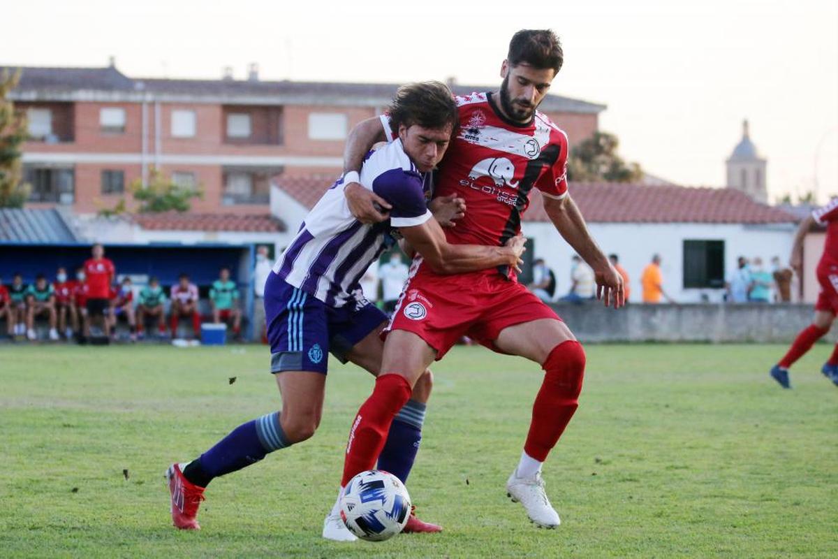 Fer Román, jugador del Unionistas, trata de robarle el balón a un jugador del Valladolid Promesas