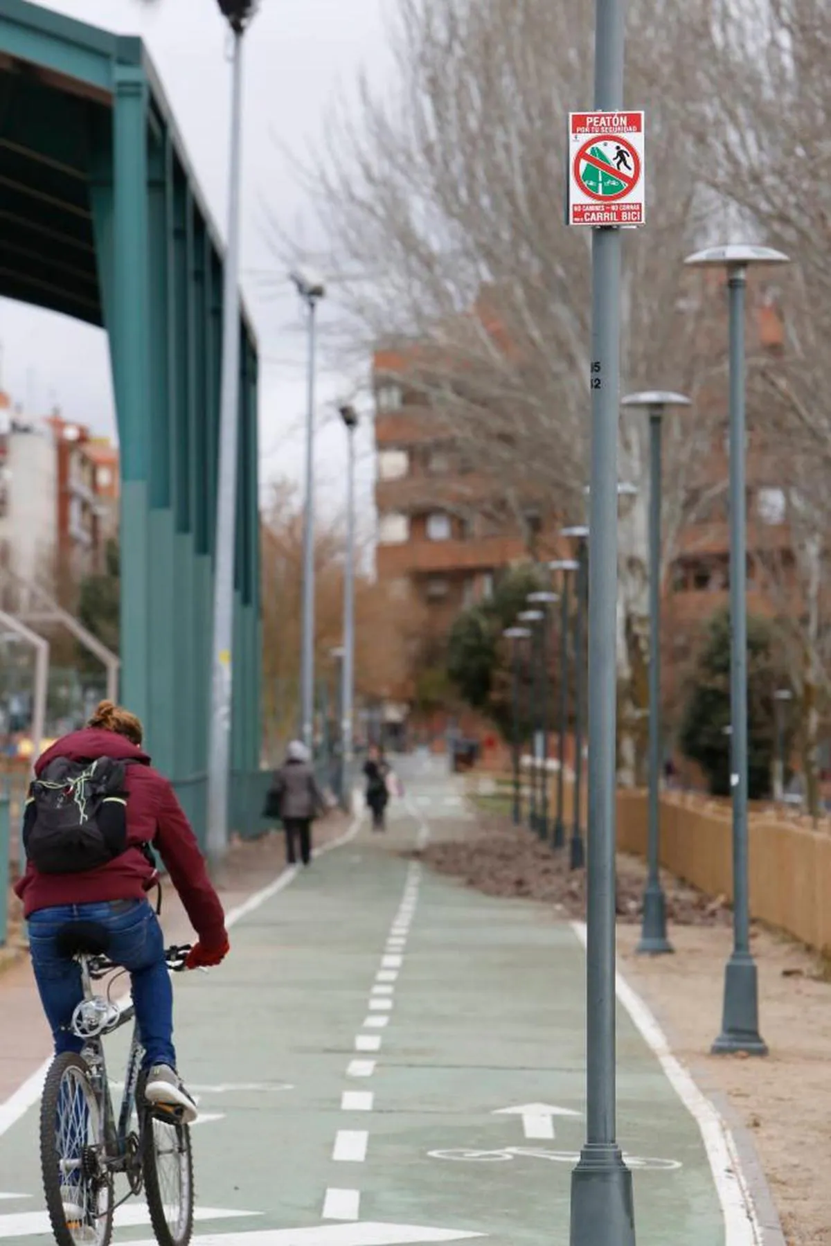 Gente en bicicleta y caminando por el carril bici