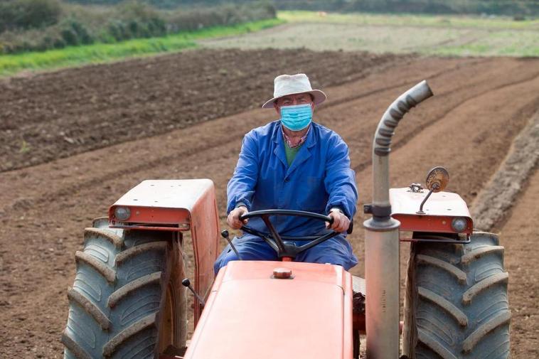 Un agricultor trabajando con su tractor