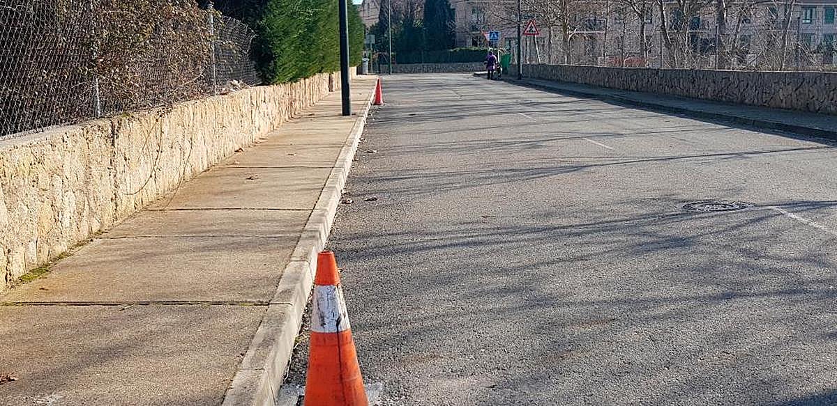 Un hombre pasea su perro por la zona de Villamayor donde han desaparecido las tapas de alcantarillas.