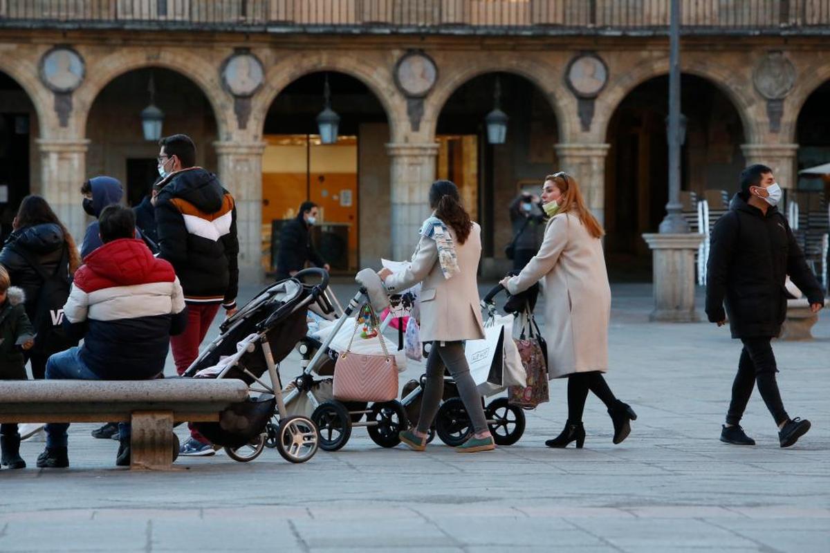 Varias familias paseando a sus hijos pequeños en carritos.