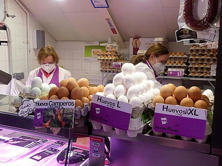 María Jesús, derecha, prepara un pedido en su pollería.