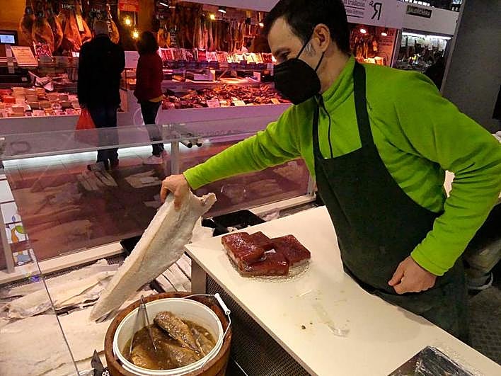 Alberto coge una pieza de bacalao salado junto a un barril de escabeche, también típico en Cuaresma.