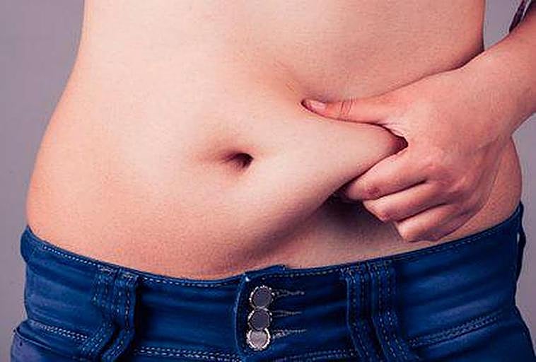 Una persona agarrándose la zona abdominal.